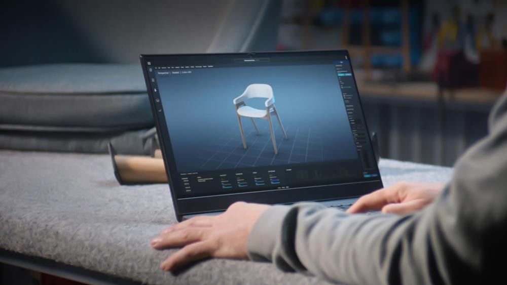 Person designing a 3D chair model on a laptop
