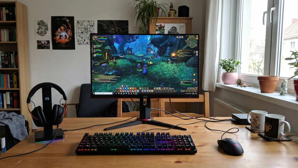 AOC gaming monitor on desk with RGB keyboard and headset
