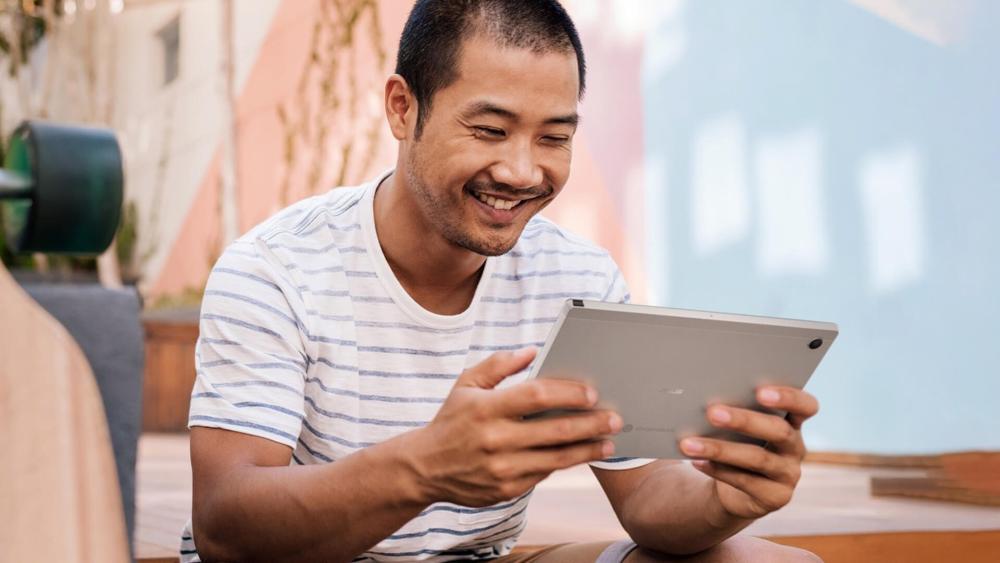 Man using an Asus Chromebook Flip in tablet mode outdoors