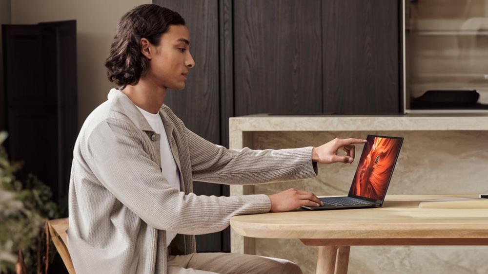 Person using Asus touchscreen laptop for enhanced experience