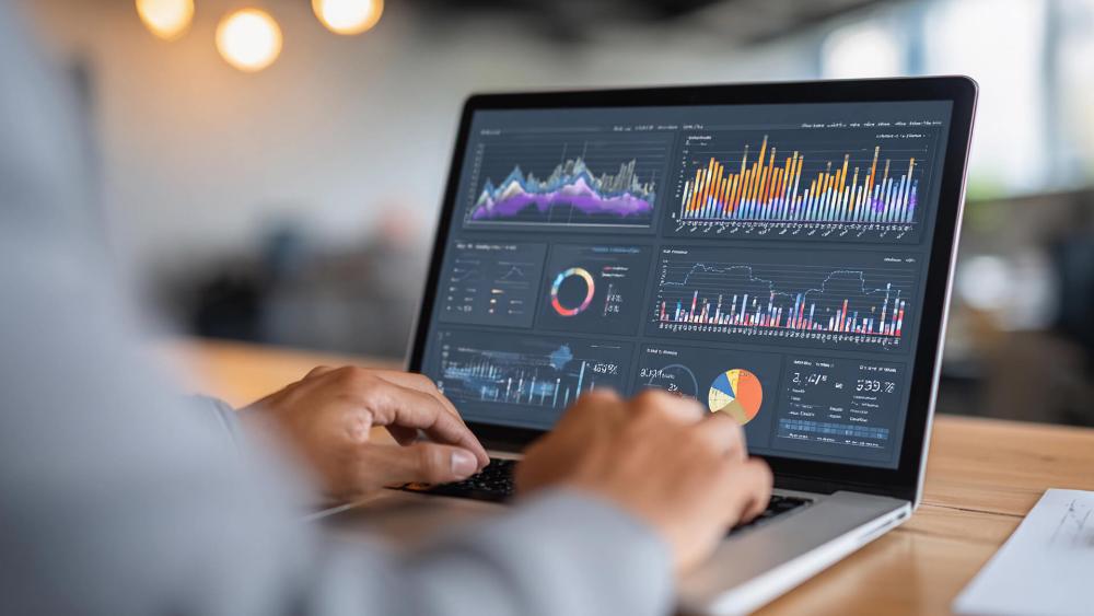 Business laptop running data analytics dashboard with multiple charts