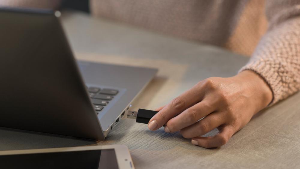 USB flash drive being connected to laptop for business data transfer