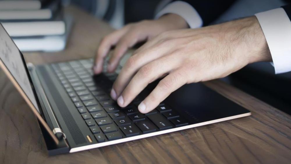 Business professional typing on a laptop keyboard, showing modern work and productivity