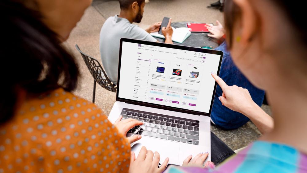 People comparing 10-inch tablet prices online on a laptop at Box