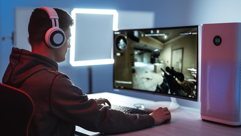 Gamer playing FPS on PC with headset setup