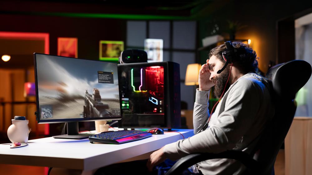 Gamer troubleshooting PC with headset and RGB desktop