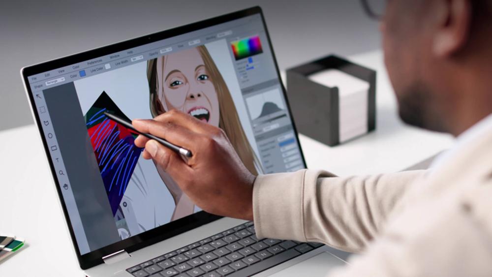 Designer sketching on rumoured touchscreen MacBook in bright workspace