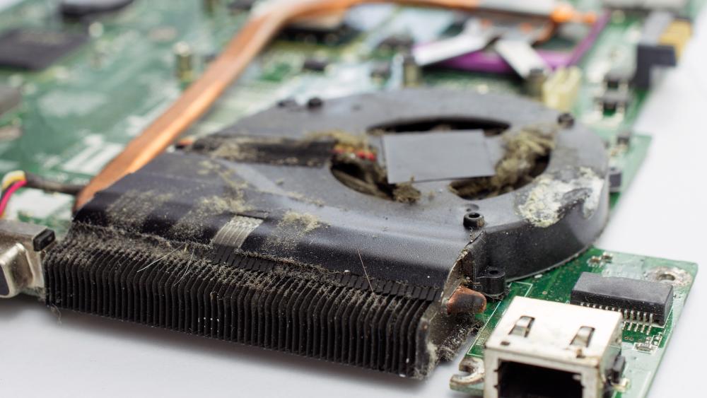 Dust buildup blocking a gaming laptop fan and heatsink