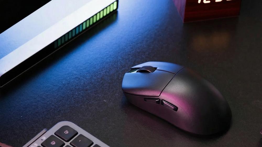 Wireless gaming mouse on desk beside keyboard