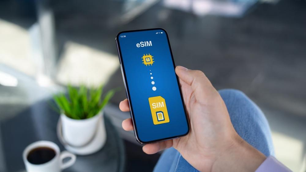 Person holding smartphone showing eSIM setup screen