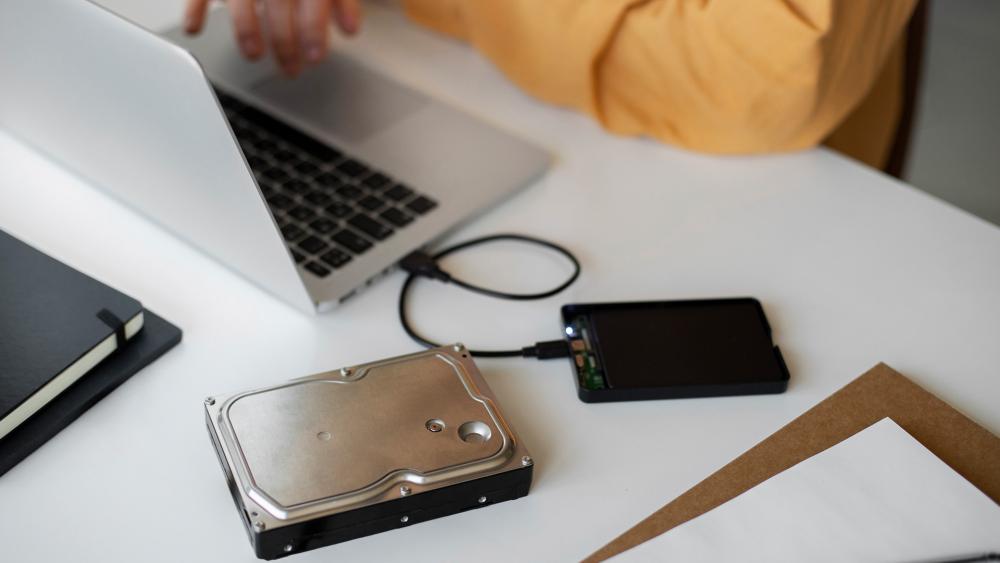 External hard drive, USB stick and disc showing different backup storage options