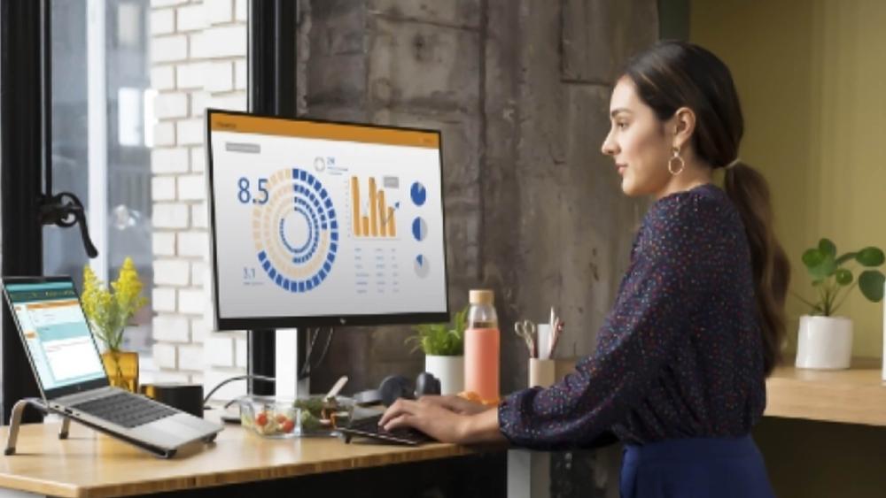 Woman reviewing analytics on an HP desktop office setup