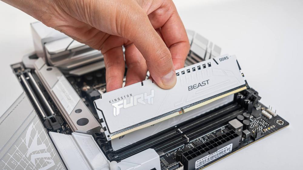 User installing Kingston Fury DDR5 RAM into motherboard slot