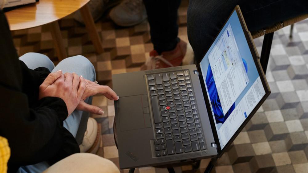 Lenovo ThinkPad business laptop used for multitasking and document work in a modern workspace setting.