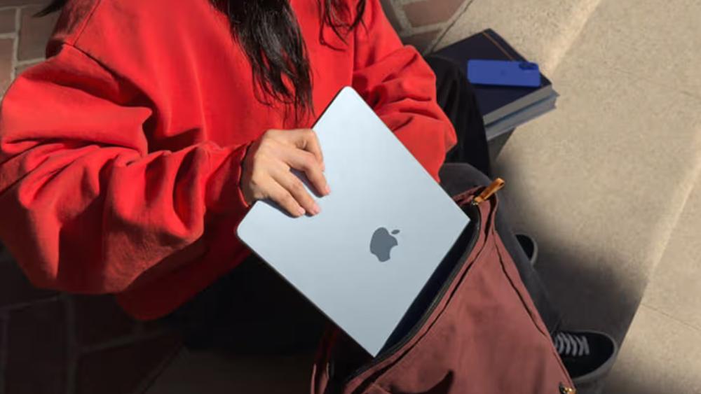 Person placing MacBook Air into bag for daily use