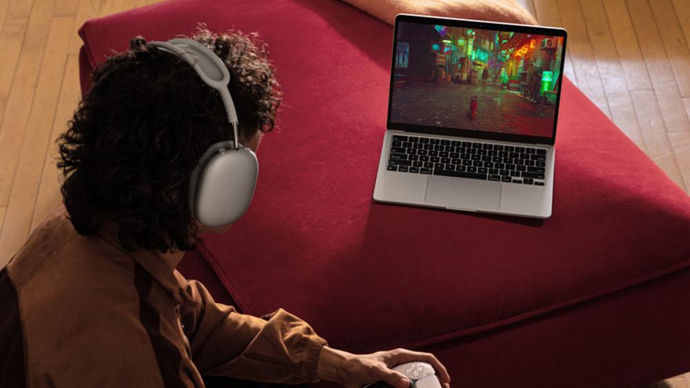 User wearing headphones using MacBook Air at home