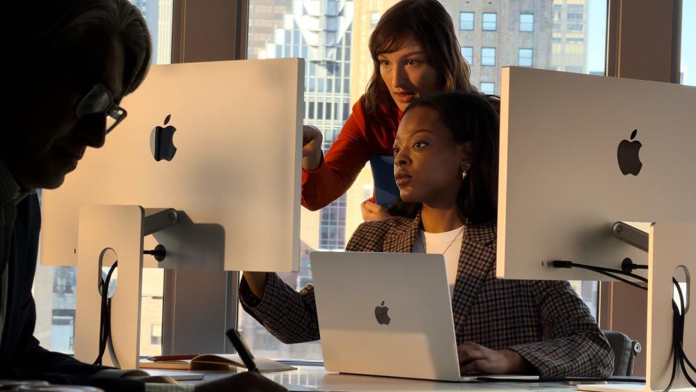 Team using MacBook Air with desktop displays in office workspace