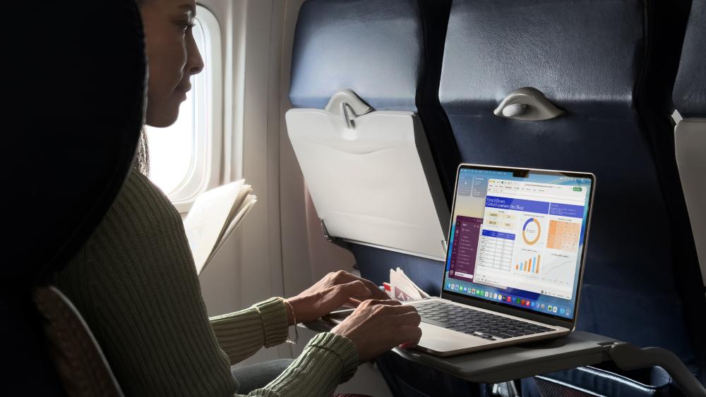 Person using MacBook laptop during flight