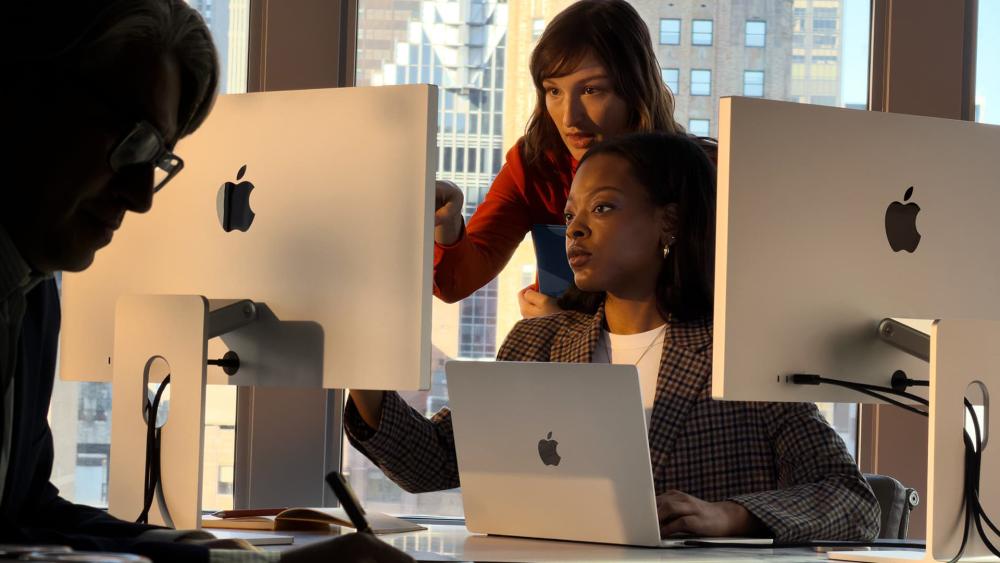 Team working with MacBook and Apple desktop displays