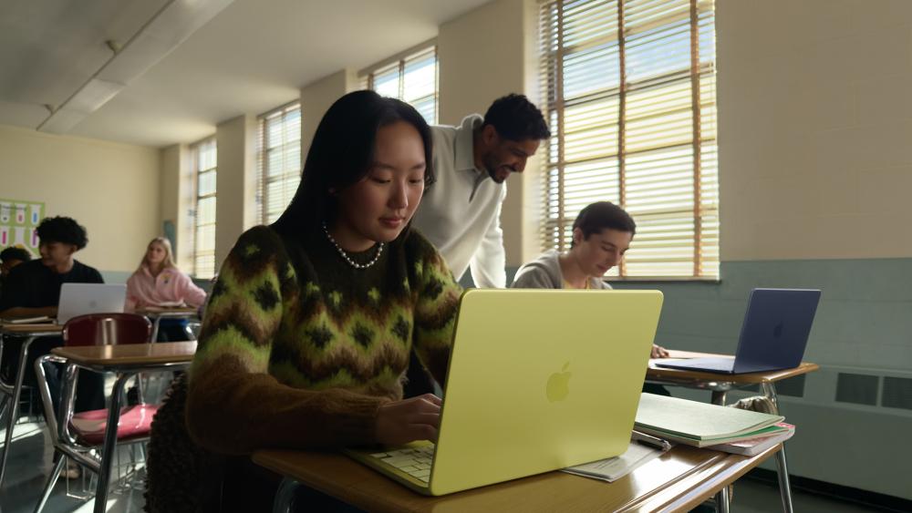 Student using MacBook laptop in classroom