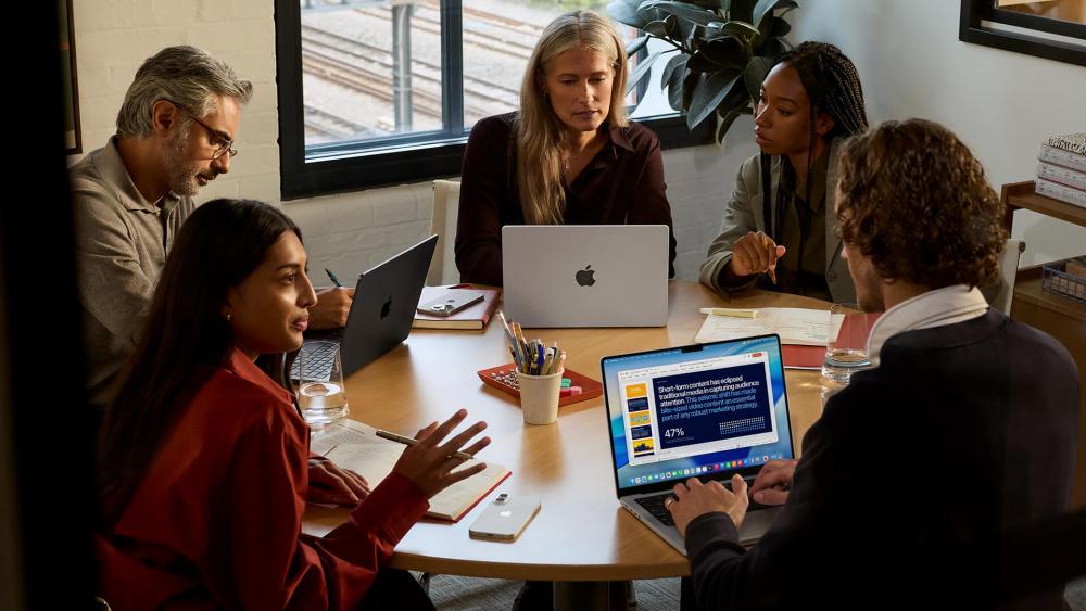 Developers collaborating with MacBook Pro in office meeting