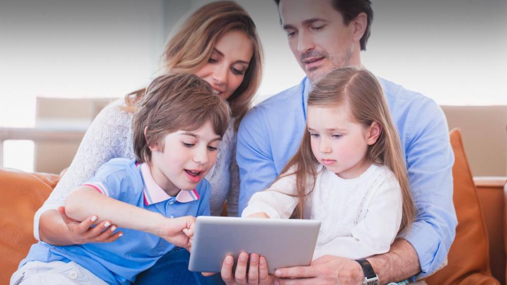 Parents and children using a shared tablet together at home