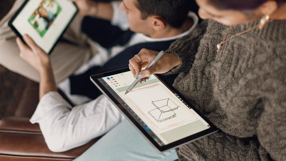 Person sketching designs on a 10-inch tablet using a stylus