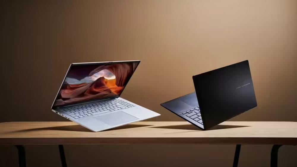 Two sleek modern laptops displayed on a table with one open showing a vibrant screen and the other partially closed, highlighting design and performance