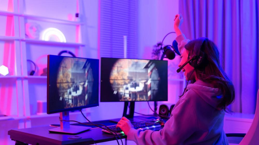 Gamer using affordable refurbished dual monitor gaming setup