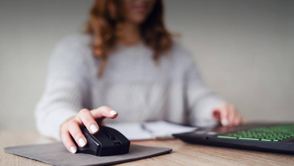 Woman using a wireless ergonomic mouse at a desk