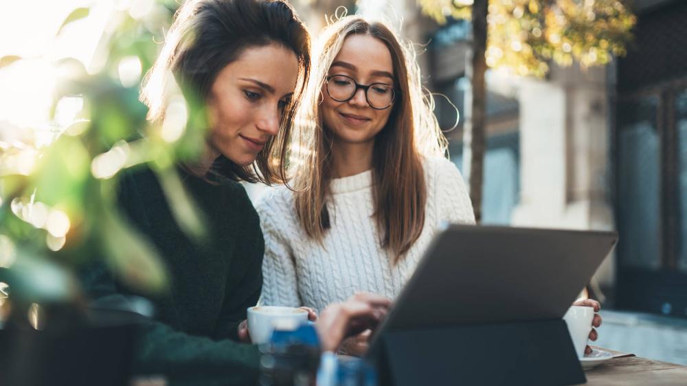 Two women researching the best Box Black Friday 2025 deals on new laptops
