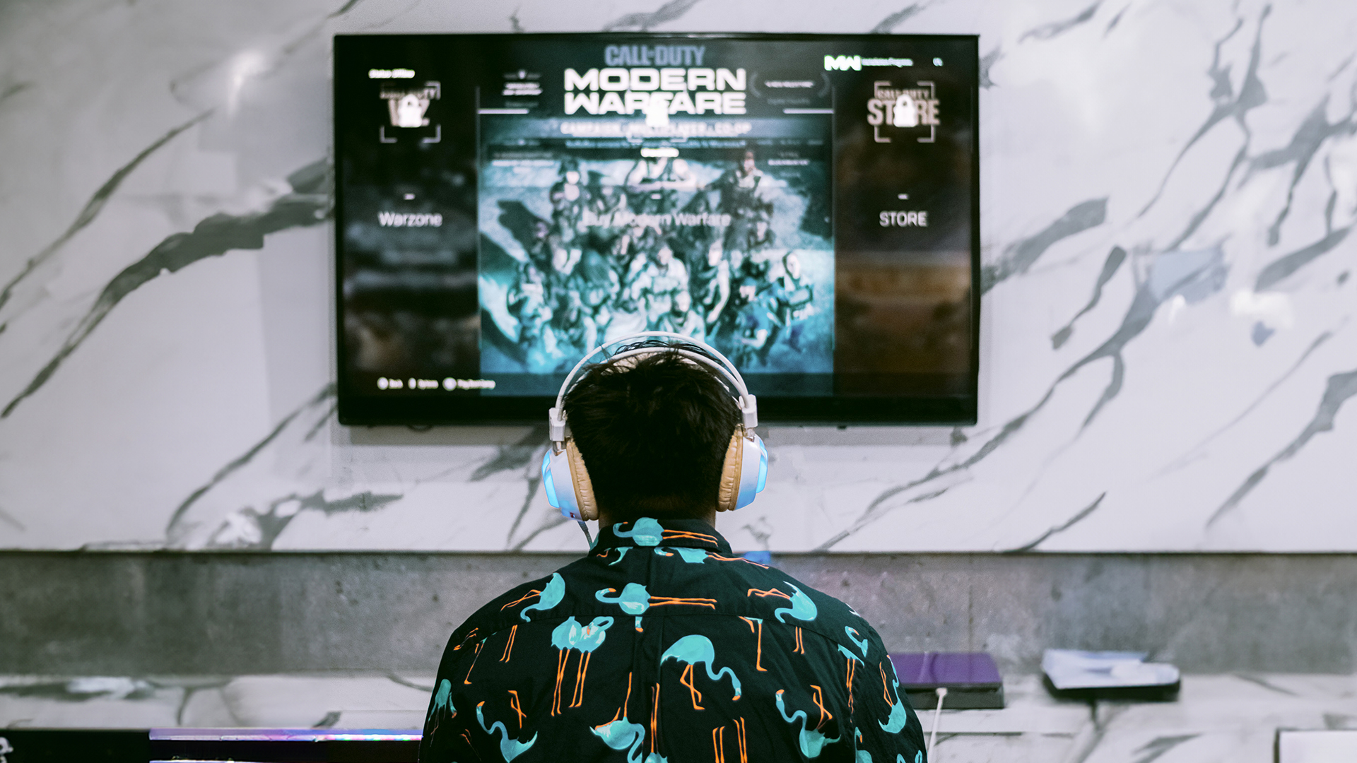 Person wearing headphones playing game on a TV screen